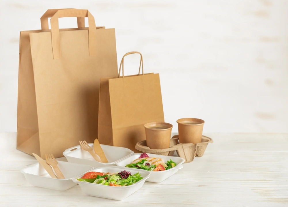 Paper bags, lunch boxes with salad and coffee cups