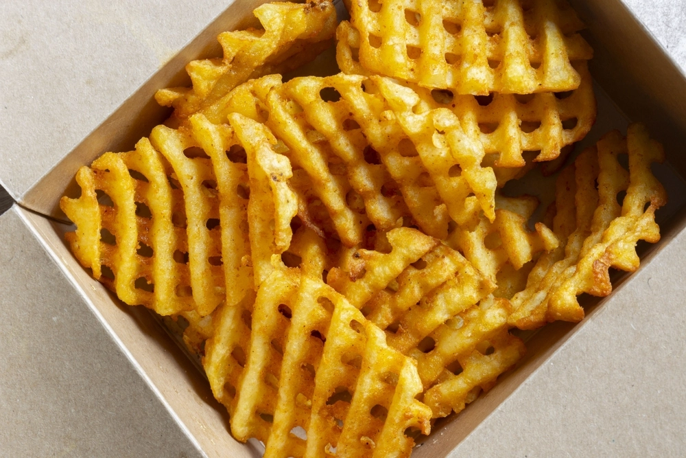 Waffle criss-cross fries takeaway in a cardboard box.